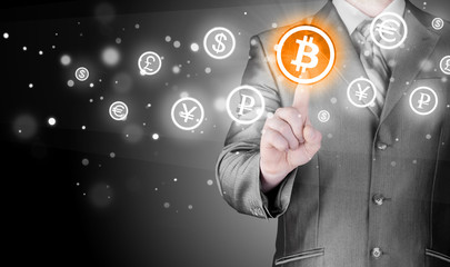 Choosing bitcoins, businessman pressing touch screen button.