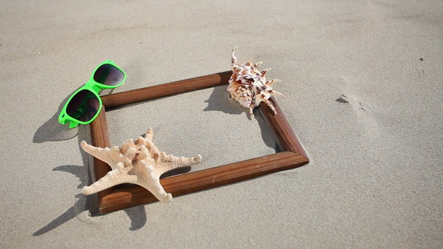 Frame with seashell, starfish and sunglasses on the beach