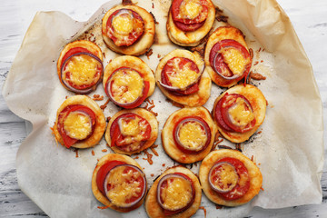 Small pizzas on baking paper close up