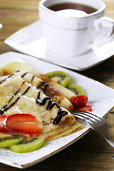 Delicious pancakes with strawberries and chocolate
