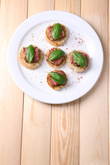 Tasty canapes with salami  and basil leaves,