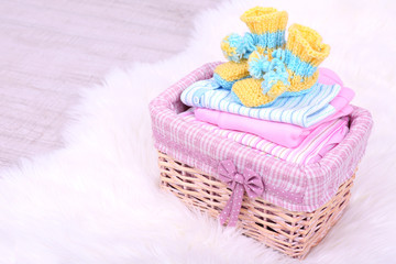 Baby clothes in basket on floor in room