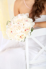 Bride holding wedding bouquet of white peonies, close-up,