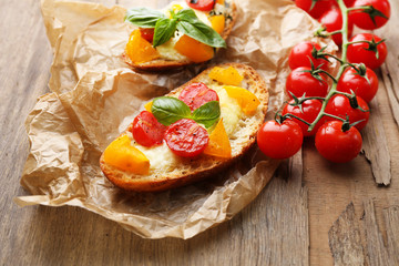 Tasty bruschetta with tomatoes, on old wooden table