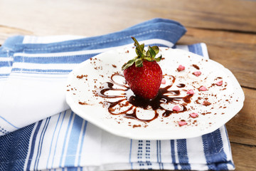 Red ripe strawberry with chocolate on wooden table