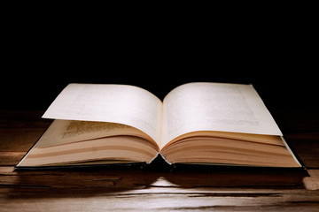 Old book on table on black background