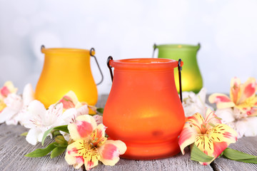 Bright icon-lamps with flowers on table on bright background