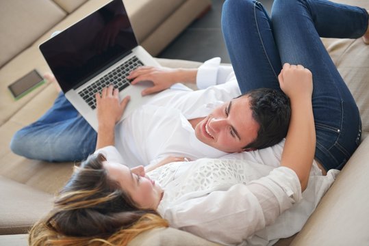 young couple using laptop at home