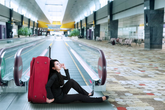Businesswoman sitting on the floor in airport