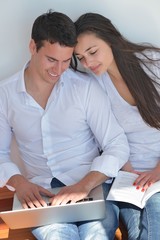 young couple using laptop at home