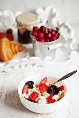 Healthy breakfast with cottage cheese, cacao, cherry and croissa