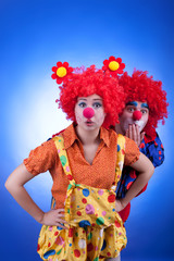 Clown couple in costumes on blue background