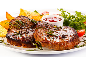 Grilled steaks, baked potatoes and vegetables