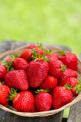 basket with strawberries on a garden wooden table
