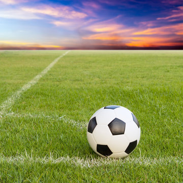 soccer ball on soccer field against sunset sky