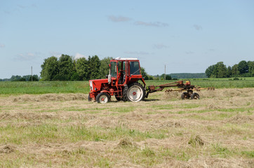 tractor ted hay dry grass in agriculture field