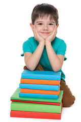 Cute young boy near books