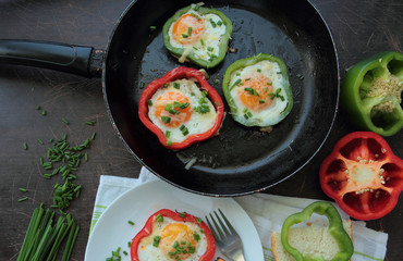 Fried eggs in peppers made on frying pan for breakfast