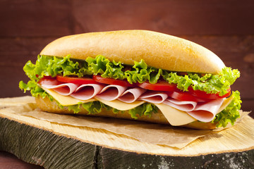 Obrazy  duża kanapka z szynką, serem i warzywami