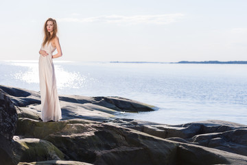 Young woman on rocky shore