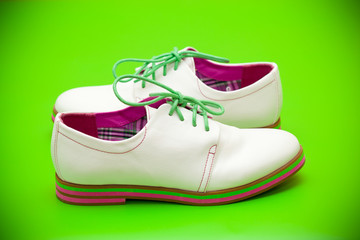 white shoes with green shoelaces on a green background