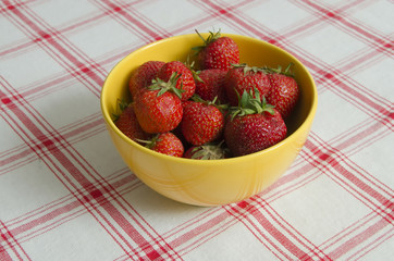 strawberries in a yellow bowl on cloth background