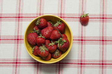 strawberries in a yellow bowl on cloth background