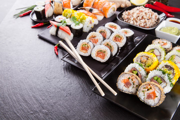 Delicious sushi pieces served on black stone