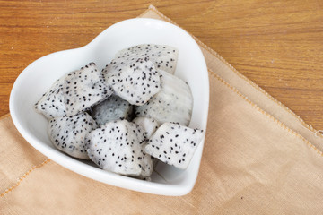 Cubic chopped dragon fruit on wood table.