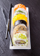 Delicious sushi pieces served on black stone