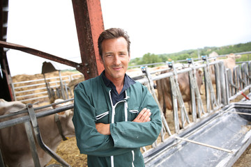 Smiling farmer standing in barn