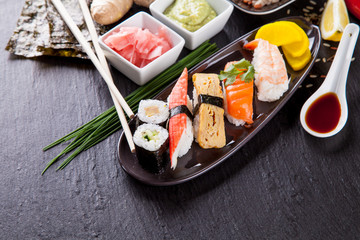 Delicious sushi pieces served on black stone