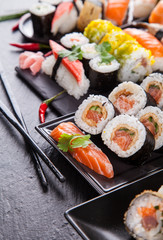 Delicious sushi pieces served on black stone