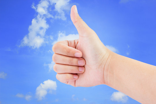 Woman hand with thumb up  on the blue sky background