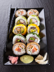 Delicious sushi pieces served on black stone