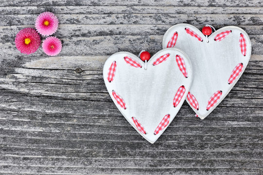 Two hearts with flowers on a wooden background old