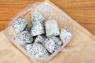 Cubic chopped dragon fruit on wood table.