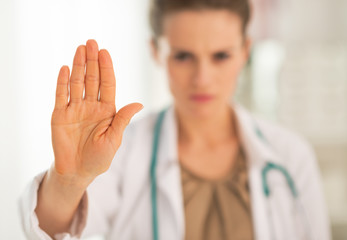 Closeup on serious medical doctor woman showing stop gesture