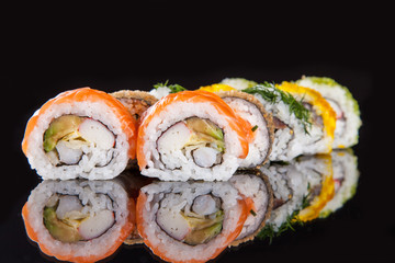Delicious sushi pieces on black background