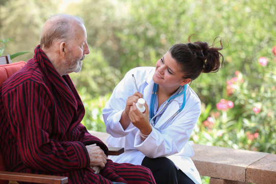 Dr or nurse giving medication to senior patient.