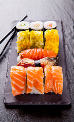 Delicious sushi pieces served on black stone