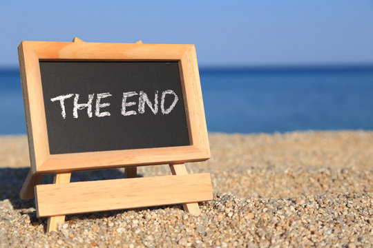 Blackboard with "The end" text on the beach