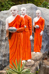 Fototapeta premium Buddhist monk statues going to Gold Buddha temple, Dambulla, Sri