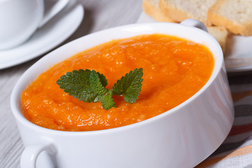 hot cream soup of carrots close-up in white plate