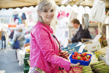 Frau kauft Erdbeeren auf dem Markt,