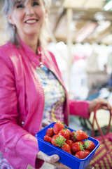 Frau kauft Erdbeeren auf dem Markt,