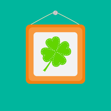 Four leaf clover in a picture frame on the wall. Flat design.