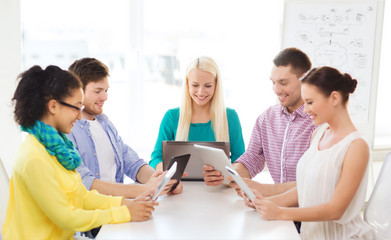 smiling team with table pc and laptop in office