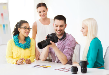 Obraz na płótnie Canvas smiling team with photocamera working in office