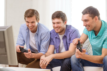 Fototapeta premium smiling friends playing video games at home